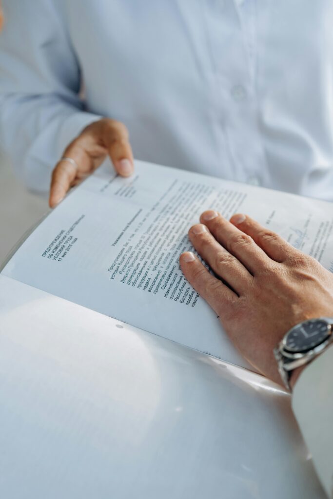 Close-up of hands reviewing a business agreement document. Professional setting.